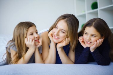 Mutlu bir aile evde oynamak. Anne ve bebek kızları rahat ol