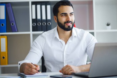 Masaüstü bilgisayar önünde ofiste çalışan adam