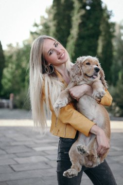 Gürültü ve klasik tarz. Köpekli genç kız parkta yürüyor ve güzel yaz gününün tadını çıkarıyor.