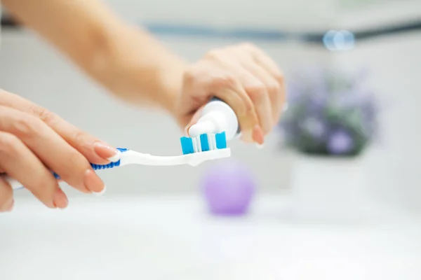 Close up hands woman use toothbrush in light bathroom — Stock Photo, Image