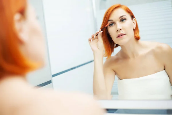Mulher com cabelo vermelho no banheiro usar produtos de cuidados — Fotografia de Stock
