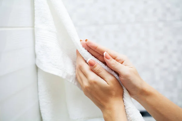 Крупним планом руки використовують білий рушник у легкій ванній кімнаті — стокове фото