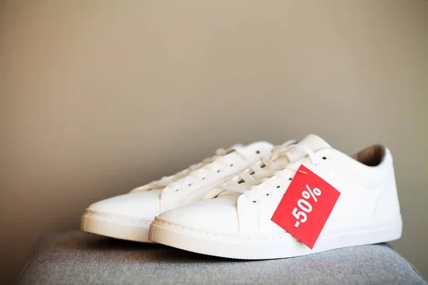Пара новых стильных белых кроссовок на полу в магазине . — стоковое фото
