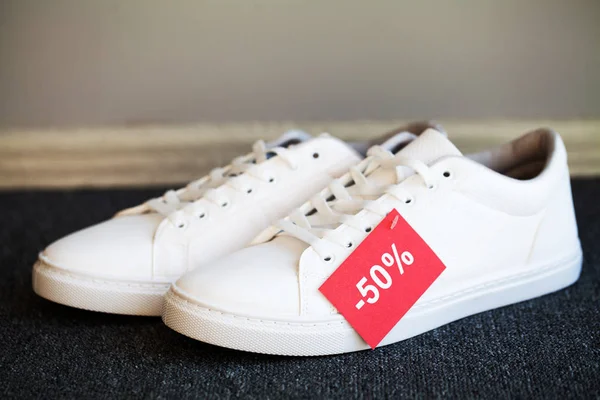 Pair of new stylish white sneakers on floor at store. — 스톡 사진