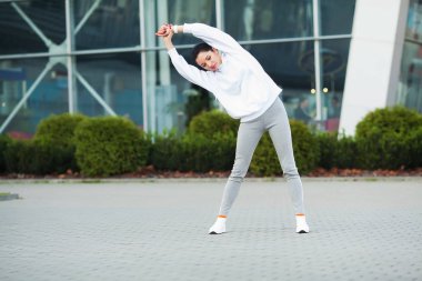 Kadın vücut germe egzersizleri Caddesi üzerinde yapıyor.