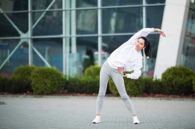 Kadın vücut germe egzersizleri Caddesi üzerinde yapıyor.