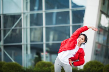 Kadın vücut germe egzersizleri Caddesi üzerinde yapıyor.