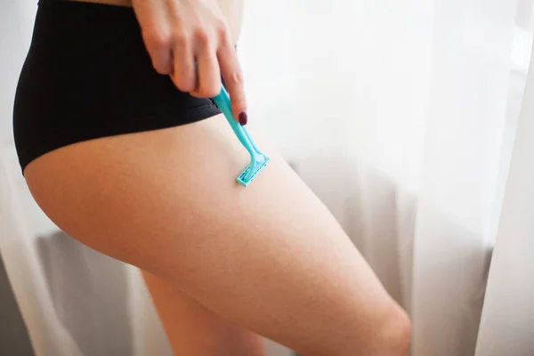 Крупним планом молода дівчина голиться ногою у ванній . — стокове фото