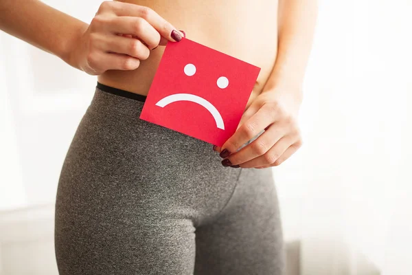 Saúde da mulher. Corpo Feminino Segurando Triste Cartão Sorridente Perto do Estômago . — Fotografia de Stock