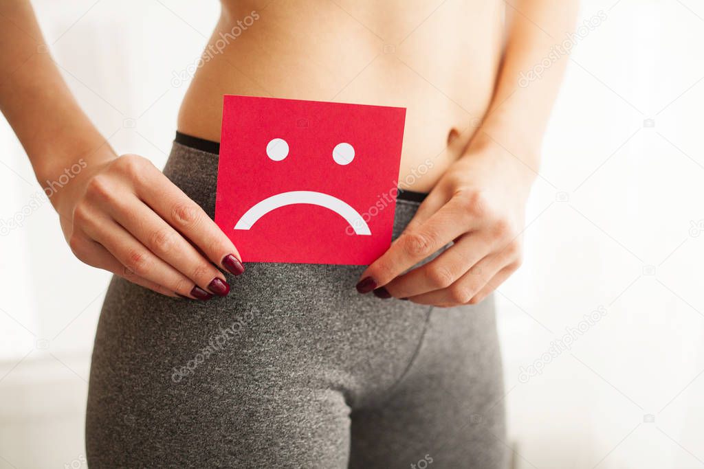 Woman Health. Female Body Holding Sad Smiley Card Near Stomach.