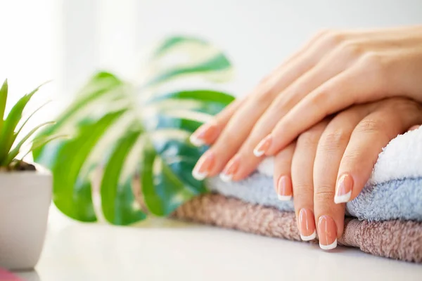 Cuidado con las uñas. Hermosas uñas de mujer con manicura francesa, en estudio de belleza —  Fotos de Stock