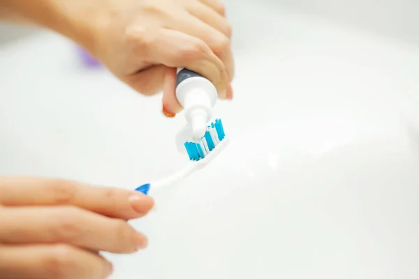 Close up hands woman use toothbrush in light bathroom — Stock Photo, Image