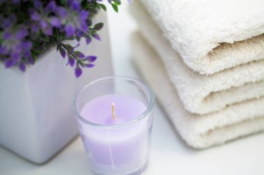 Güzellik salonunda beyaz ahşap masa üzerinde kozmetik ürünler ve pamuklu havlu