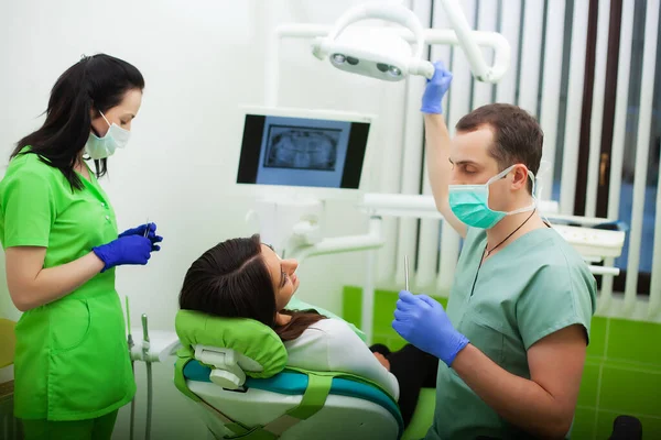 The dentist man are treating teeth to client in dental office — Stock Photo, Image