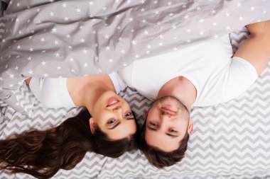 Mutlu çift yatakta eğlenmek. Birbirlerine zevk yatak odasında samimi şehvetli genç çift