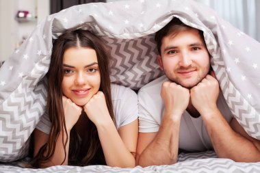 Mutlu çift yatakta eğlenmek. Birbirlerine zevk yatak odasında samimi şehvetli genç çift