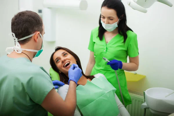 The dentist man are treating teeth to client in dental office — Stock Photo, Image