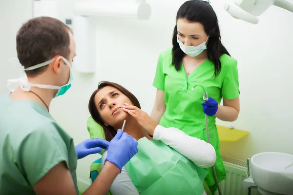 Tandläkare mannen behandlar tänder till klienten i tandläkarens — Stockfoto