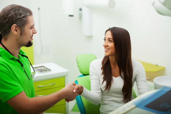 Dentiste dans le cabinet dentaire parler avec la patiente et se préparer pour le traitement — Photo