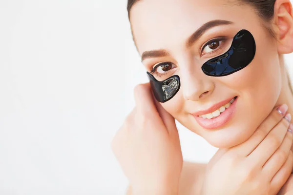 Mascarilla para el cuidado de la piel. Mujer con parches negros . — Foto de Stock