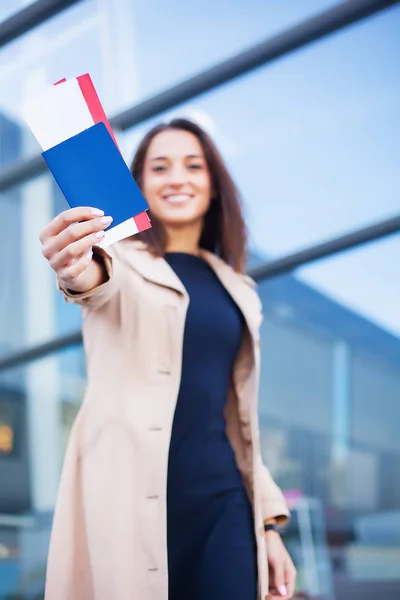 Kobieta posiadająca dwa bilety lotnicze za granicą paszport w pobliżu lotniska — Zdjęcie stockowe