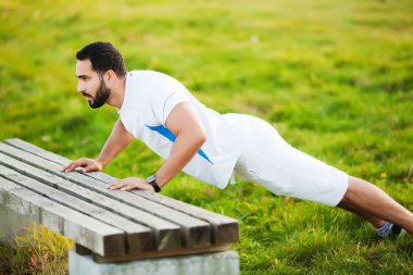 Fit muscular man running outside. Fitness and sport concept