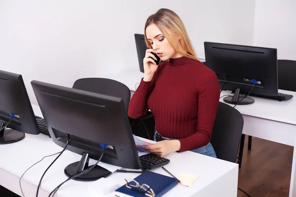 Woman sitting at desk, working on laptop in modern office — Stock Photo, Image