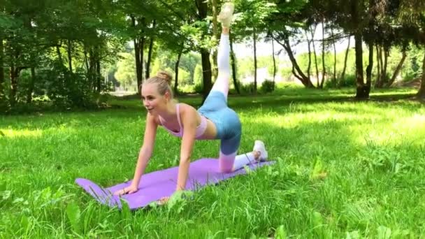 Fitness. Vrouw doet stretching oefening in park — Stockvideo