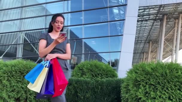 Mujer sosteniendo bolsas de colores cerca de su centro comercial de rodaje en vacaciones de viernes negro — Vídeos de Stock