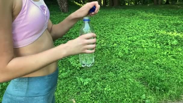 屋外フィットネス。女性の飲料ボトルに水の — ストック動画