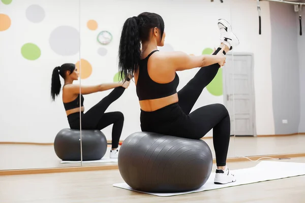 Femme en forme. Jeune femme attrayante faisant des exercices dans la salle de fitness . — Photo