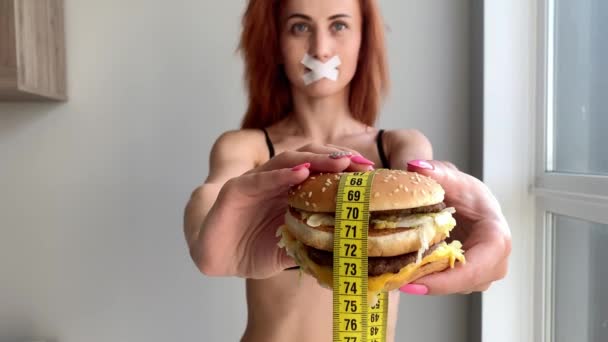 Dieet. Jonge vrouw die haar belet om junk food te eten. Gezond eetconcept — Stockvideo