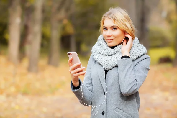 Joven belleza mujer escuchando música en otoño bosque — Foto de Stock