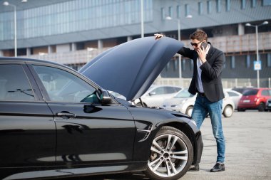 Yolun ortasında kırık arabalı bir adam var.