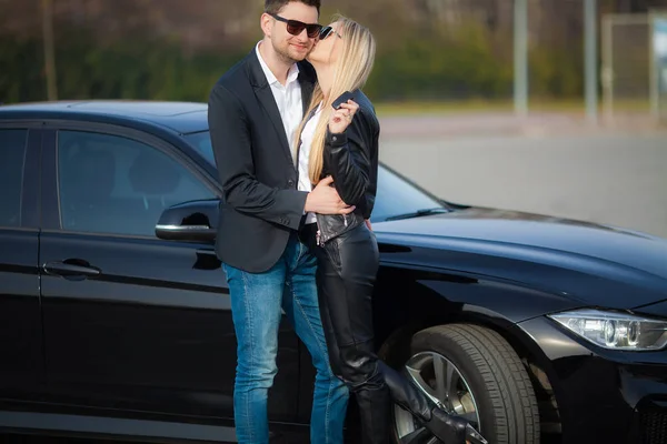 Счастливая пара купить новый современный черный автомобиль — стоковое фото