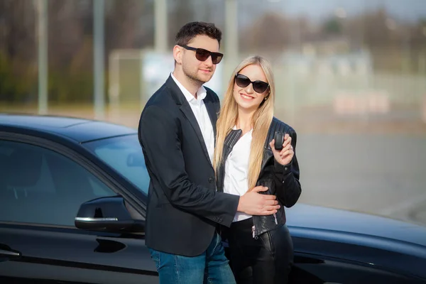 Счастливая пара купить новый современный черный автомобиль — стоковое фото