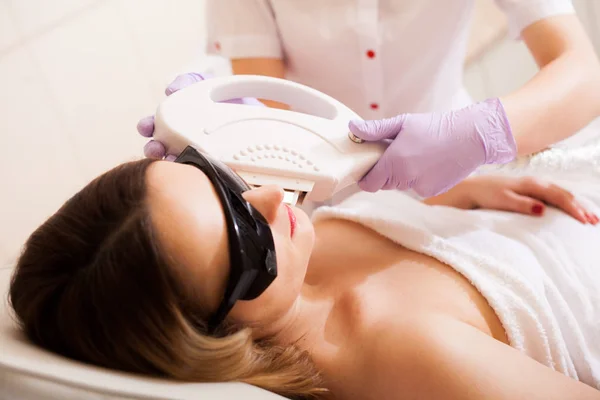 Mujer recibiendo tratamiento de depilación láser en su cara —  Fotos de Stock