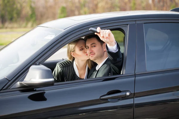 Casal feliz comprar novo carro preto moderno — Fotografia de Stock