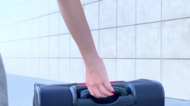 Bayan yolcu çıkış kapısına doğru ilerliyor. Bavulu havaalanı koridorundan geçiriyor.