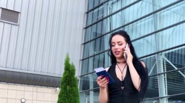 Tatil. Gülümseyen kadın yolcu havaalanı yolcu salonundan bavulçekerek kapıdan çıkışa doğru ilerliyor