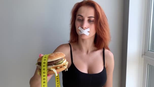 Woman wants to eat a Burger but stuck skochem mouth — Stockvideo