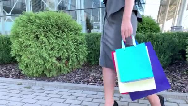 ショッピング。ブラックフライデーの休日に彼女のシューピングモールの近くに色のバッグを保持している女性 — ストック動画