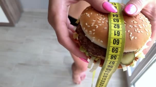 Mujer quiere comer una hamburguesa pero pegado skochem boca — Vídeo de stock