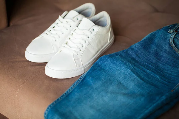 Jeans och sneakers på brun bakgrund. — Stockfoto