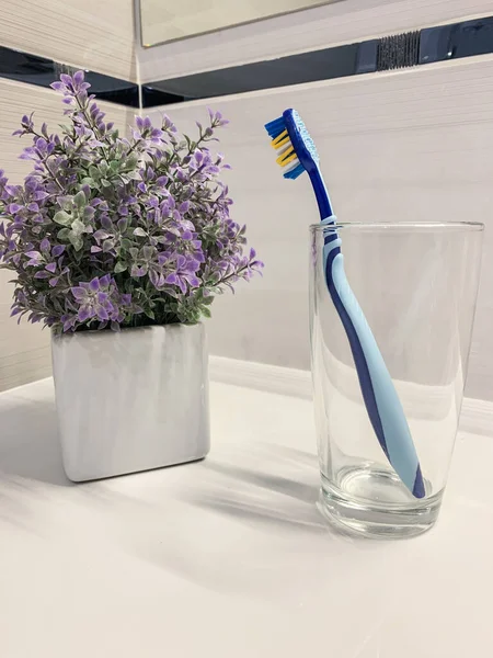 Blue toothbrush in glass for brushing the teeth. — Stock Photo, Image
