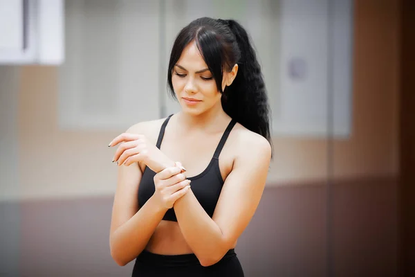 Fitness vrouw doet oefeningen in de sportschool en voelt pijn in de hand. — Stockfoto