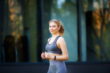 Kadın açık havada egzersiz sırasında telefonda müzik dinleme