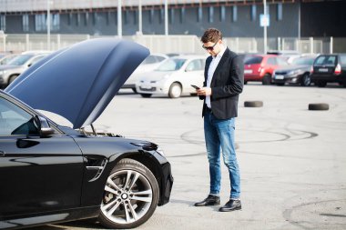 Yolun ortasında kırık arabalı bir adam var.