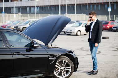 Yolun ortasında kırık arabalı bir adam var.