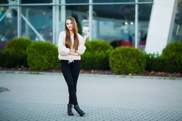 Schöne Frau, die Karten mit lustigem Lächeln hält — Stockfoto